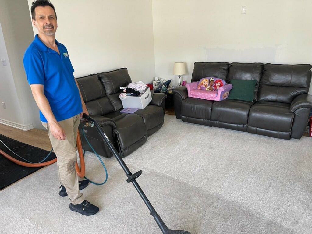 Carpet cleaning professional Jamie using a truck-mount system to clean a customer's living room carpet.