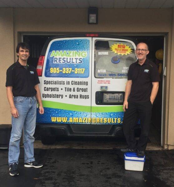 Jamie and Todd from Amazing Results Cleaning Solutions in front of their carpet cleaning truck outside a home in Oakvile, ON.